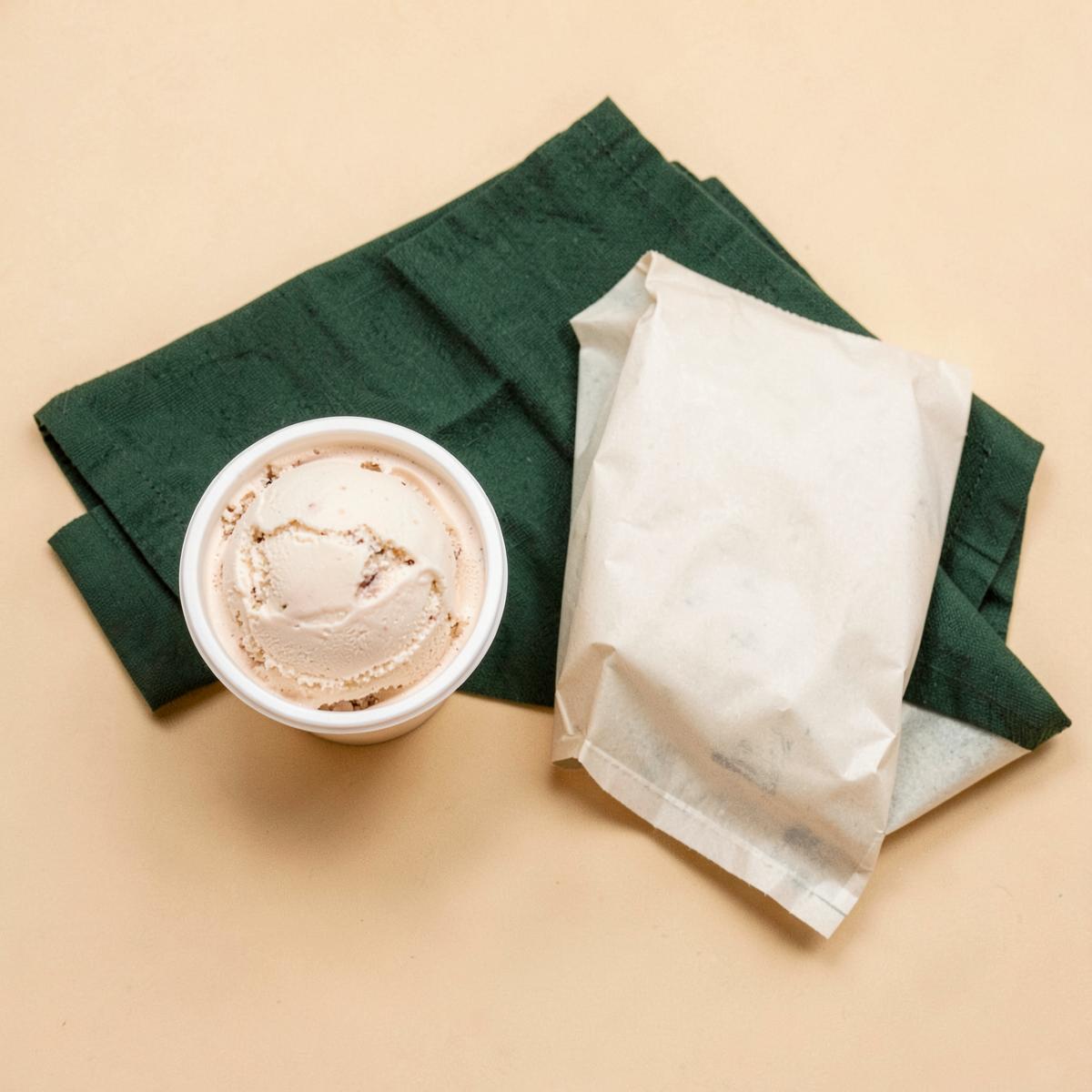Tarrina de helado para llevar junto a una bolsa de papel